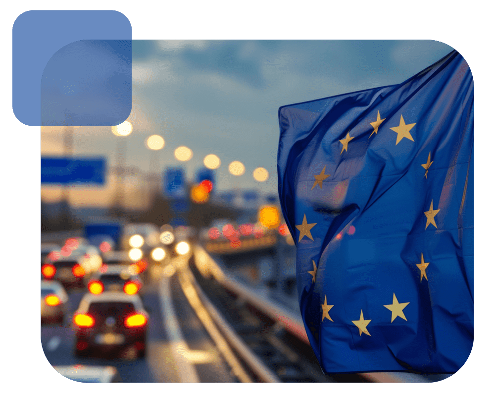 Die EU-Flagge weht vor einer stark befahrenen Autobahn.