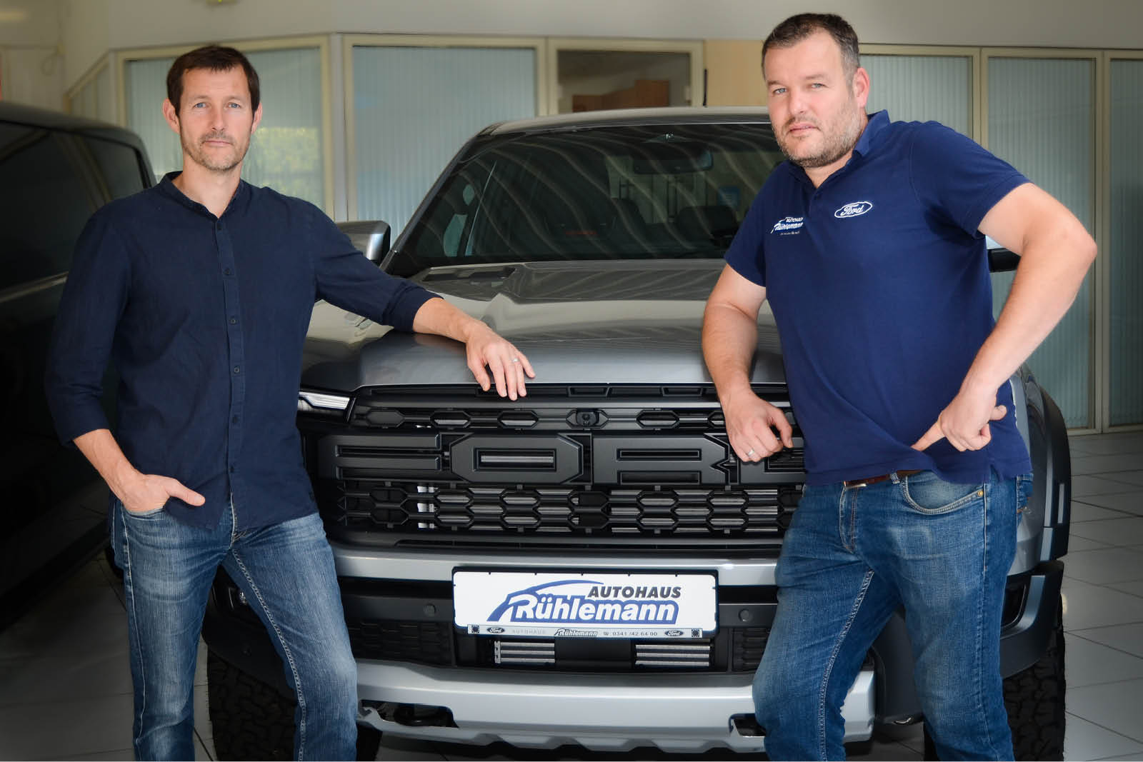 Zwei Mitarbeiter vor einem Ford-Fahrzeug.